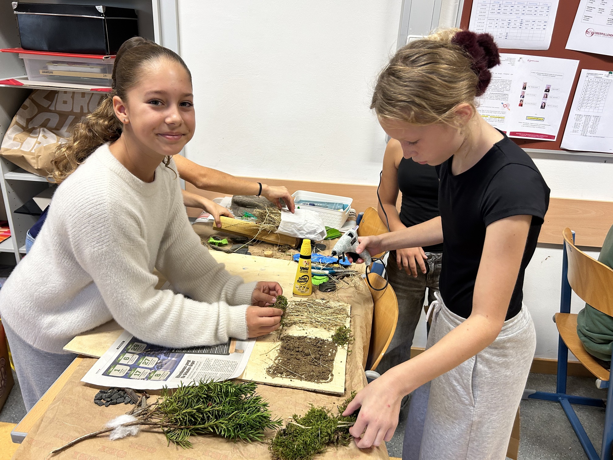 Kinder basteln mit Naturmaterialien in einem Klassenzimmer in Österreich.